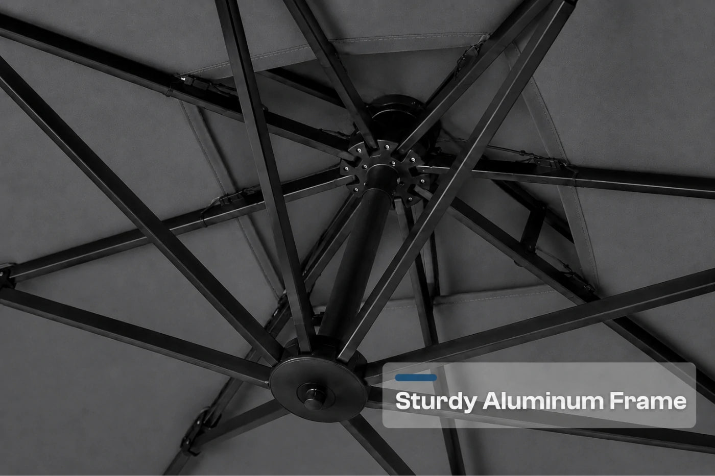Close-up of a patio umbrella frame made of sturdy aluminum, viewed from underneath as the canopy is folded down. A text overlay in the bottom right corner reads 'Sturdy Aluminum Frame'.
