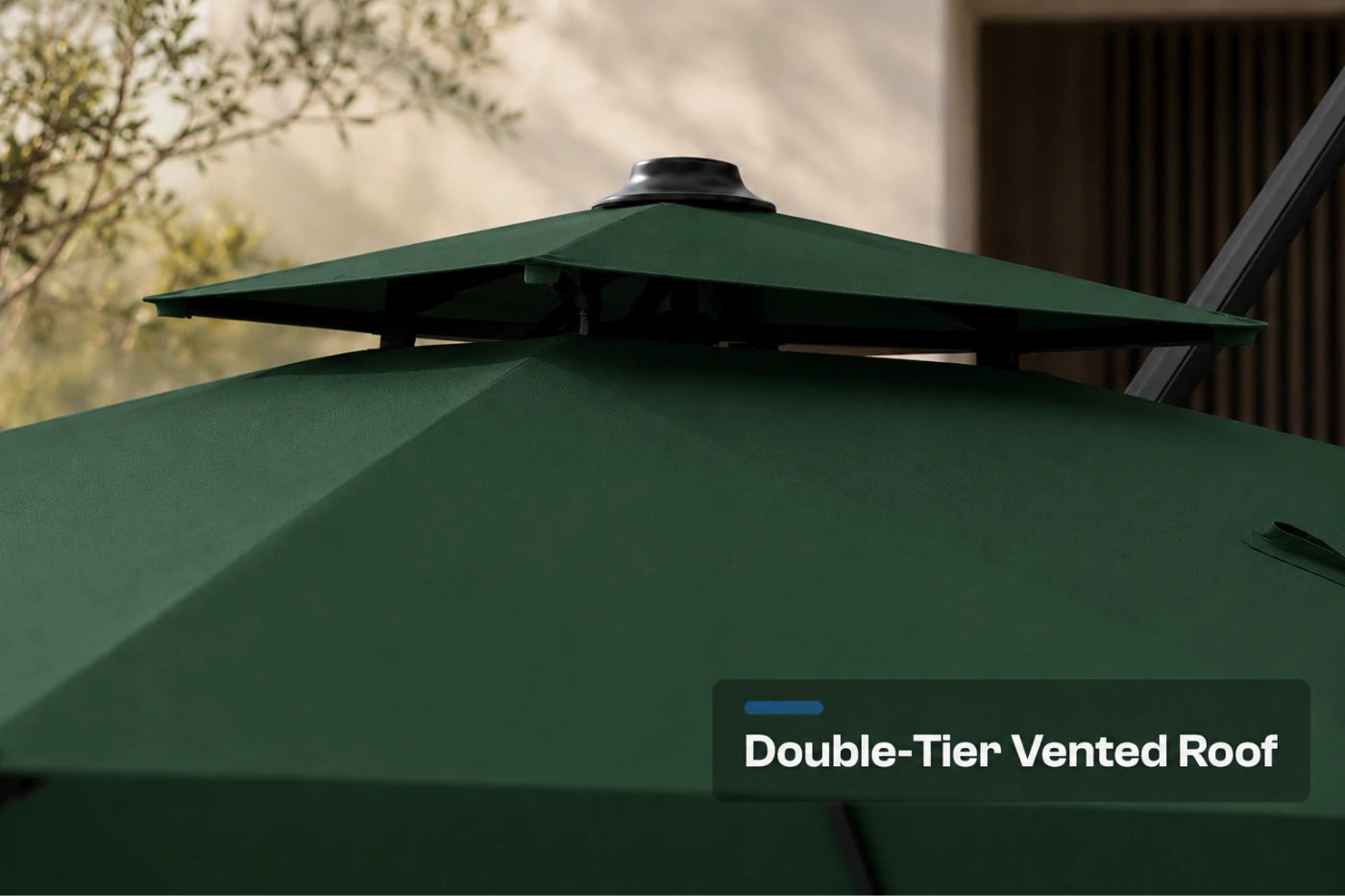 Close-up of a dark green patio umbrella showing its double-tier vented roof structure with a text overlay that reads 'Double-Tier Vented Roof'.