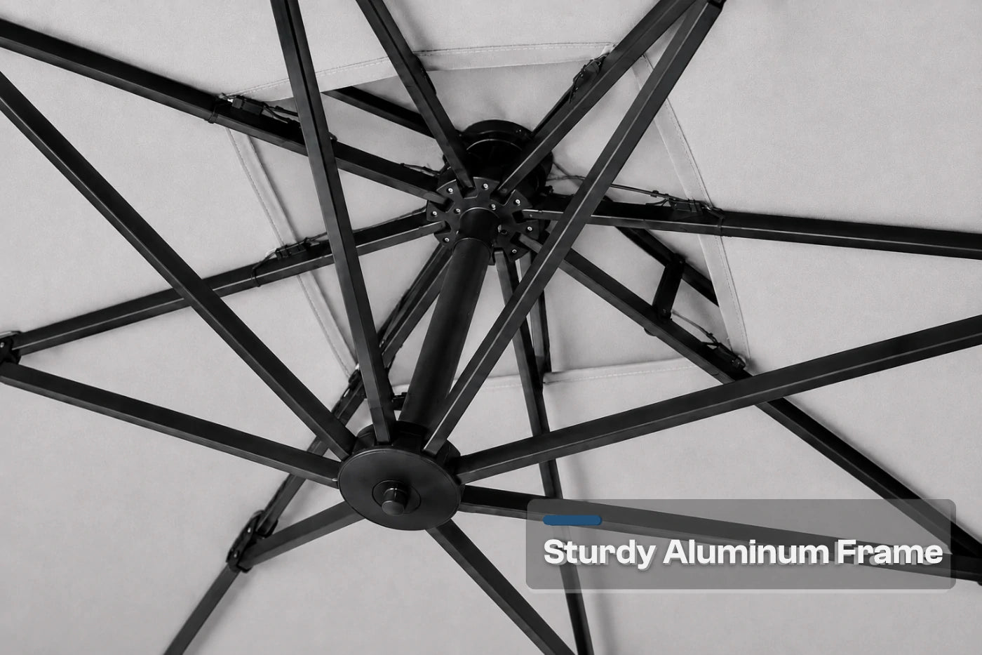 Close-up of a black aluminum patio umbrella frame with radiating ribs and a central hub, shown against a gray background with a text overlay reading 'Sturdy Aluminum Frame'.