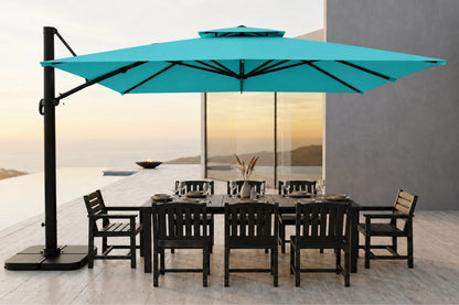 A large turquoise cantilever patio umbrella with a black pole stands beside a dark outdoor dining table and chairs on a patio at sunset.