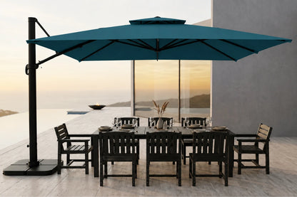 A large lake blue cantilever patio umbrella shading a dark outdoor dining table and chairs on a modern terrace at sunset.