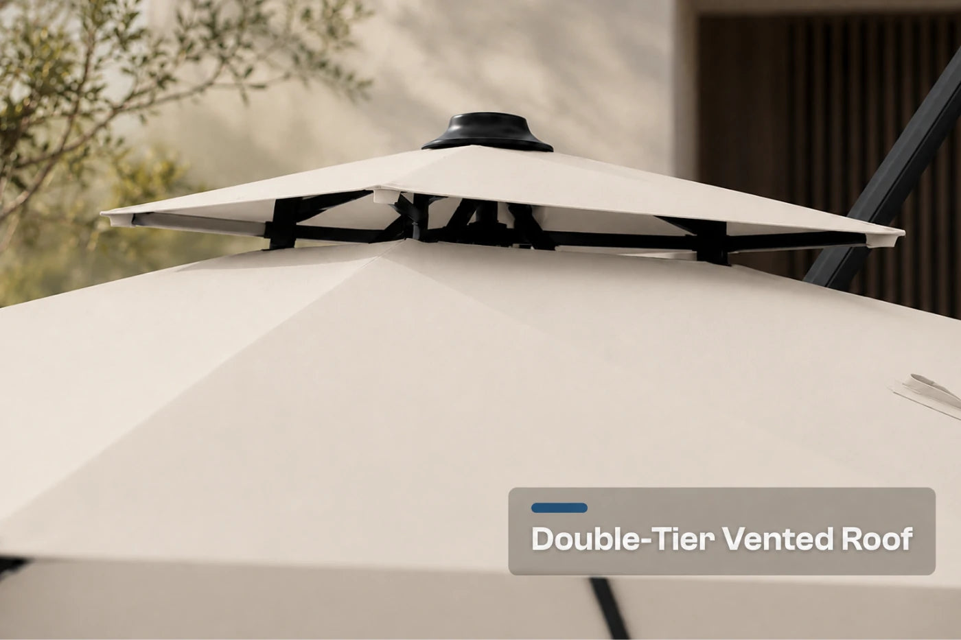 Close-up of a patio umbrella showing a double-tier vented roof design, with a text overlay reading 'Double-Tier Vented Roof' on a neutral outdoor background.