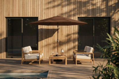 Outdoor patio set with chairs, table, and umbrella against a wooden wall.