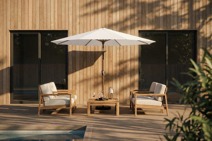 Outdoor patio set with chairs, table, and umbrella against a wooden wall.