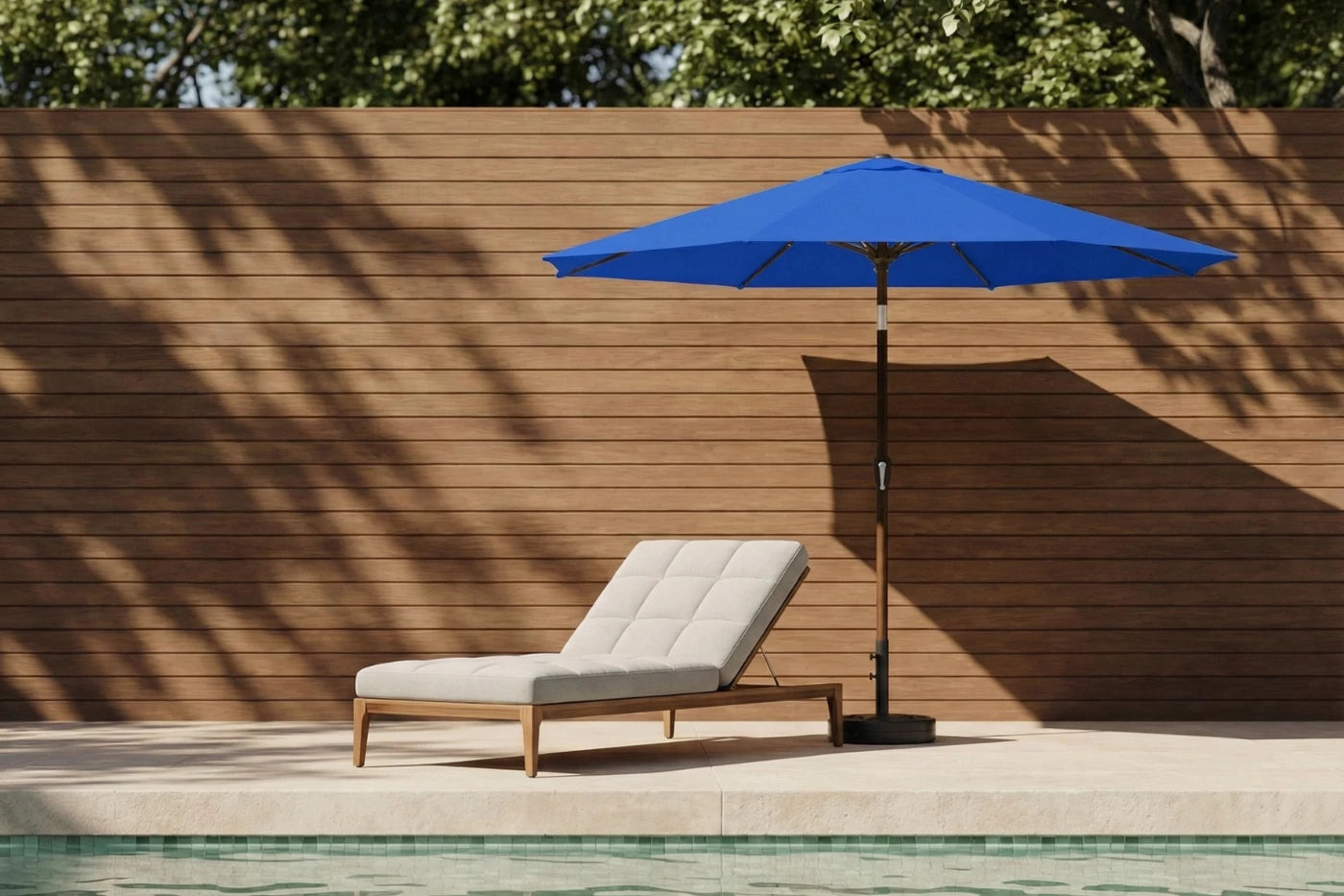 Blue outdoor umbrella and lounge chair by a poolside with wooden wall background