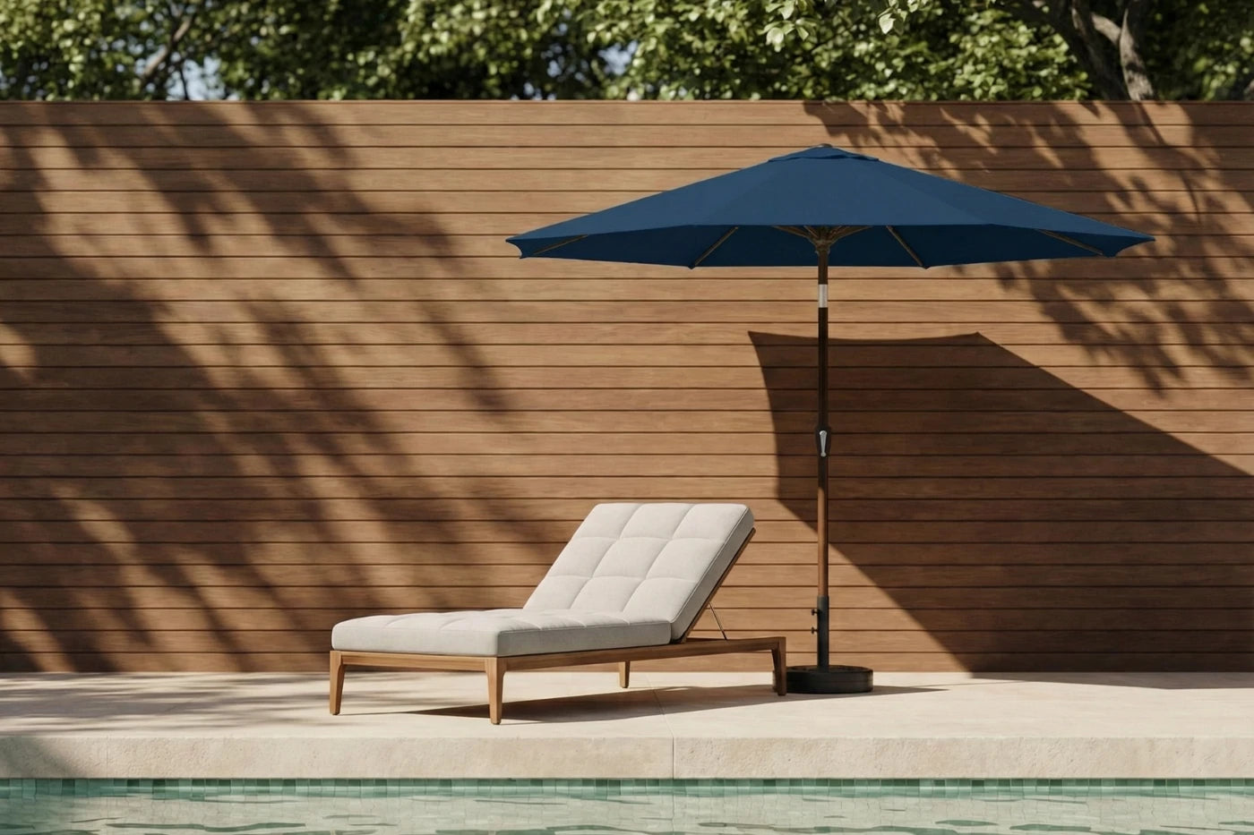 Blue patio umbrella and lounge chair by a poolside with wooden wall background