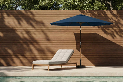 Blue patio umbrella and lounge chair by a poolside with wooden wall background
