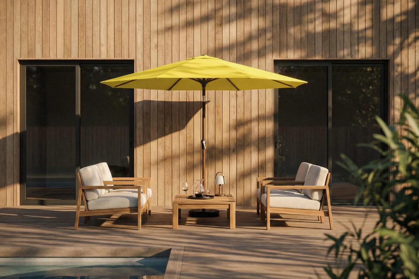 Outdoor patio set with two chairs and a table under a yellow umbrella on a wooden deck.