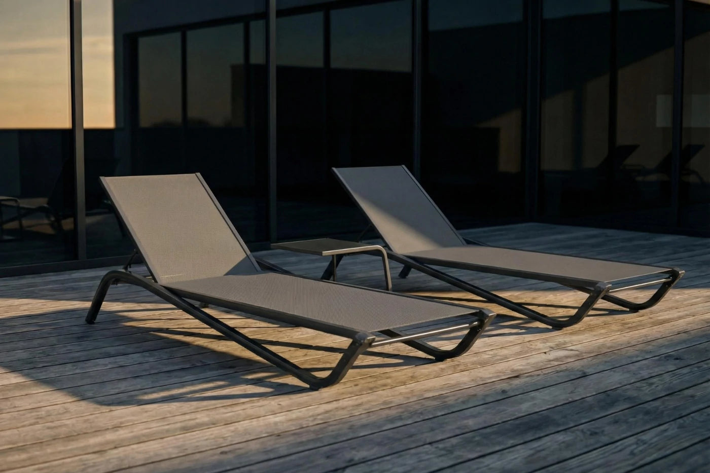 Two lounge chairs on a wooden deck with a building in the background