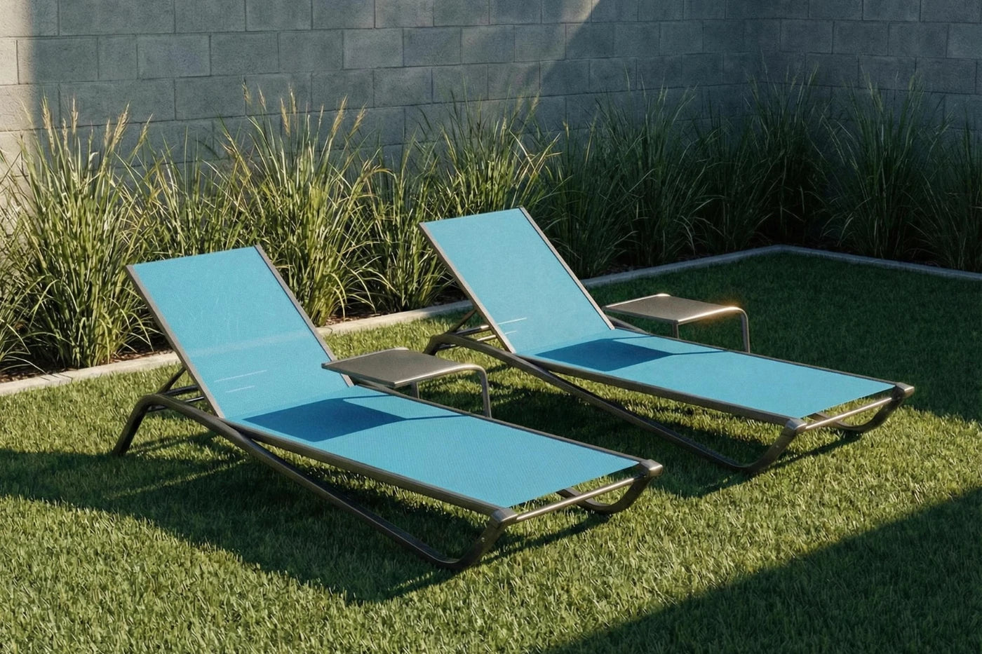 Two blue lounge chairs on grass with a stone wall background