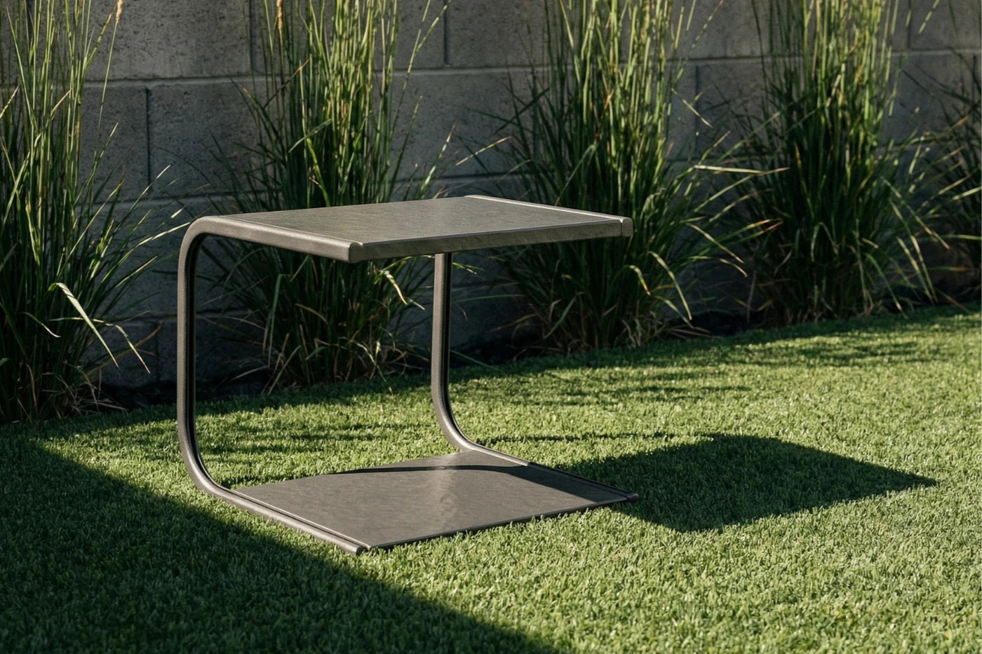 Modern outdoor table on grass with a stone wall background