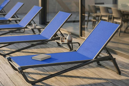 Blue lounge chairs on a wooden deck with a blurred background