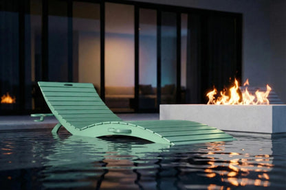 Green lounge chair in a pool with a fire pit in the background