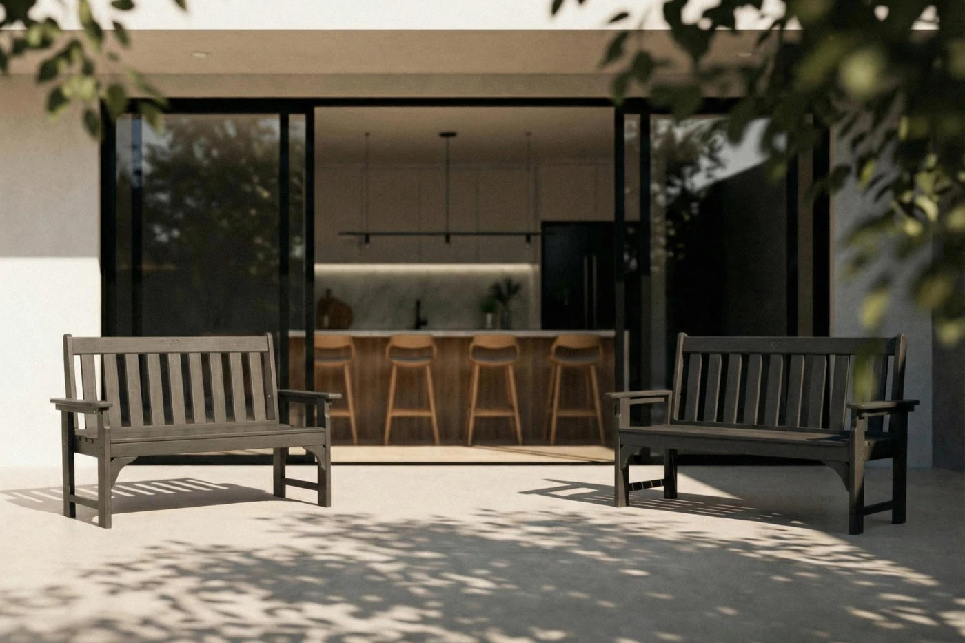 Two wooden benches on a patio with a modern house interior in the background.