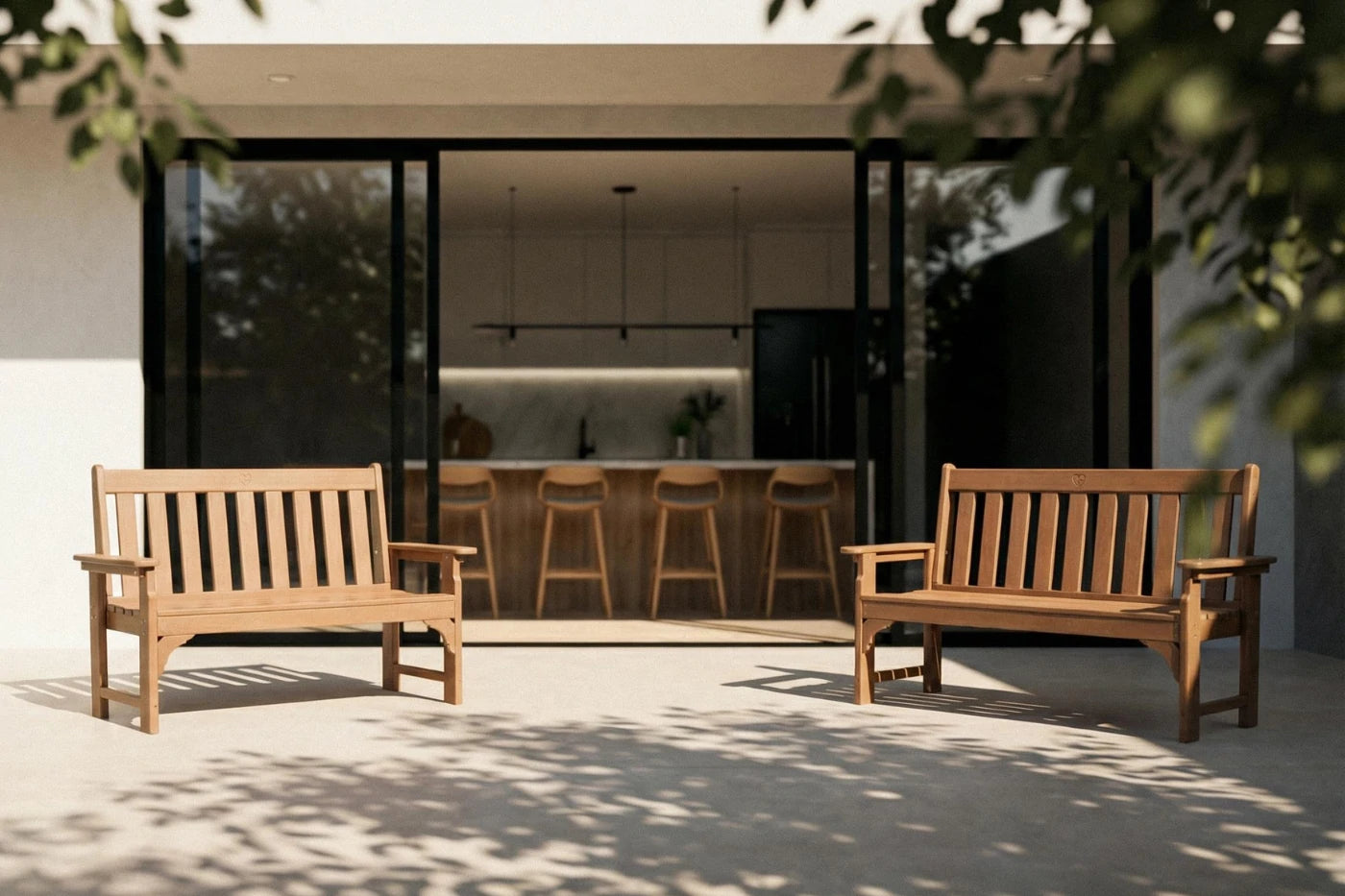 Two wooden benches in a modern outdoor setting with a house in the background.