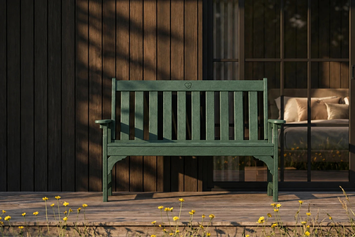 Dark green bench on a wooden deck with a blurred background