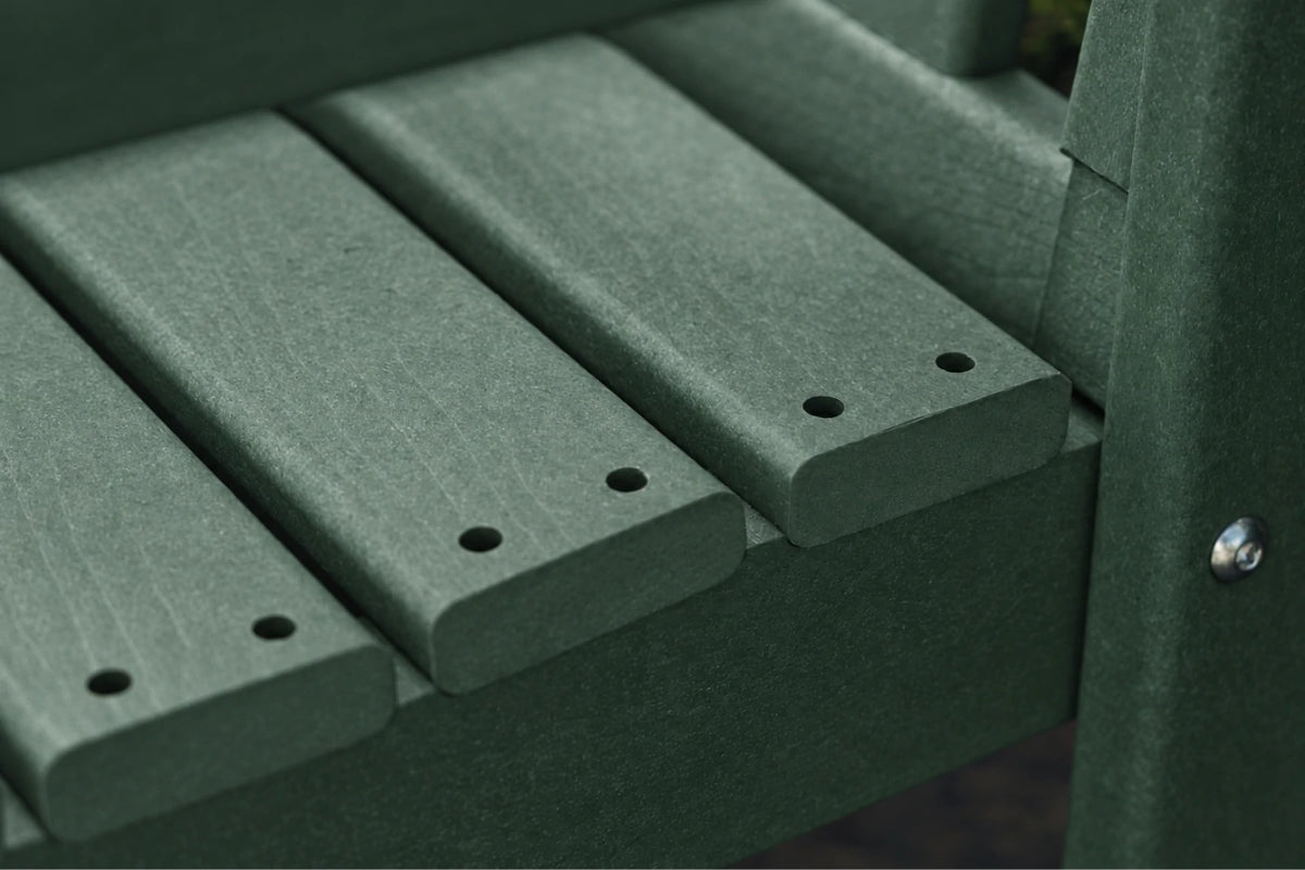 Close-up of a dark green bench with slats