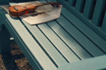 Small wooden guitar on a blue bench with a blurred background