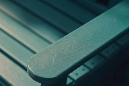 Close-up of a green metal bench with visible wear and tear.