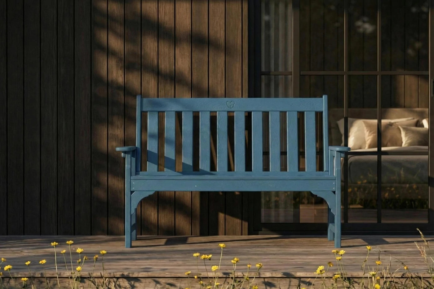 Blue bench on a wooden deck with a dark wooden wall and glass door in the background.