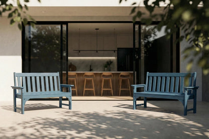 Two blue benches on a patio with a modern house interior visible through large windows.
