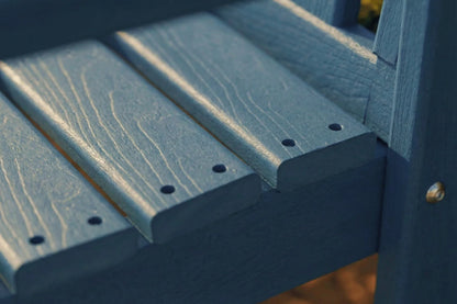 Close-up of a blue wooden chair seat with visible grain and screws.