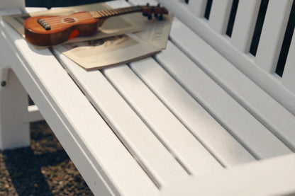 Small guitar on a magazine on a white bench