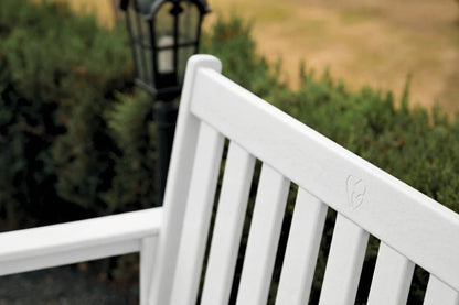 White bench with a blurred garden background