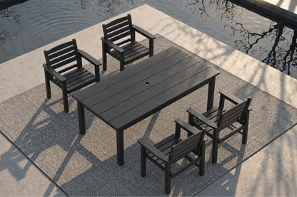 A 5-piece outdoor dining set consisting of a rectangular slatted table and four matching armchairs, shown from an elevated angle on a textured rug next to a concrete patio and water.