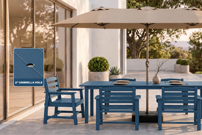 Outdoor patio dining set with a blue table and chairs under a large beige umbrella, shown on a modern patio with a glass door and potted plants. A blue inset graphic on the left highlights the umbrella hole for depth perception.