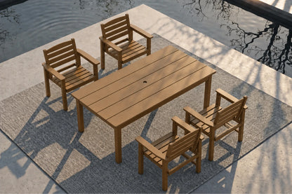 A 5-piece outdoor dining set consisting of a rectangular slatted brown table and four matching armchairs, arranged on a textured gray rug next to a concrete patio and water.