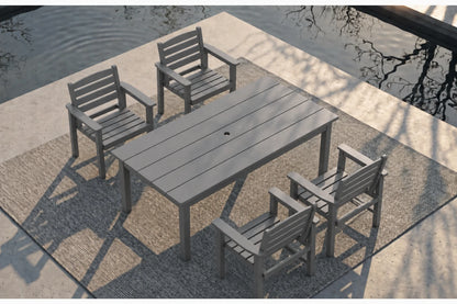 A 5-piece gray outdoor patio dining set consisting of a rectangular slatted table and four matching armchairs, arranged on a textured rug beside a concrete deck and water.