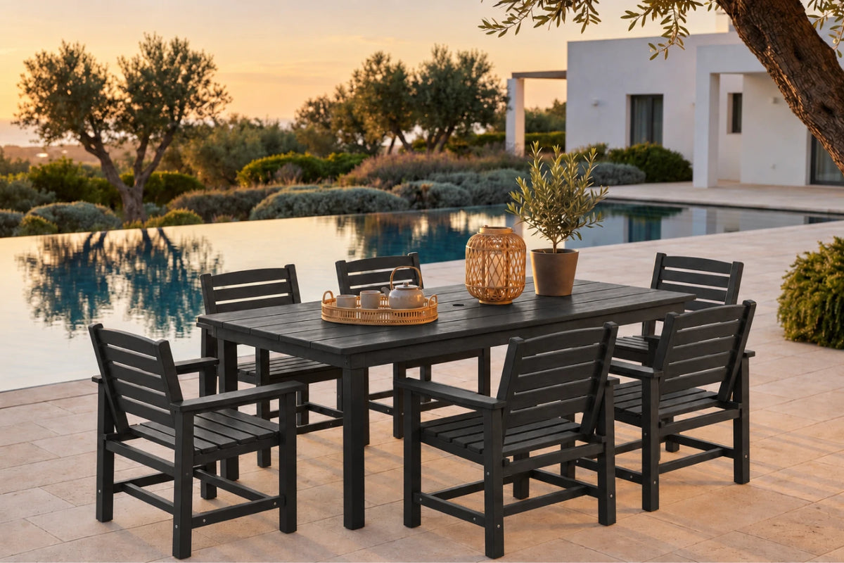 A 7-piece outdoor dining set consisting of a rectangular slatted table and six matching armchairs in black, styled on a stone patio next to an infinity pool at sunset.
