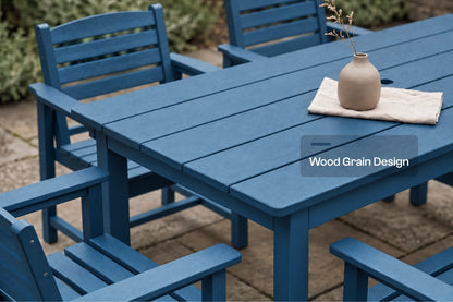 A blue outdoor dining table with matching slatted chairs on a stone patio, with a small beige vase and cloth on the tabletop. A text overlay reads 'Wood Grain Design'.