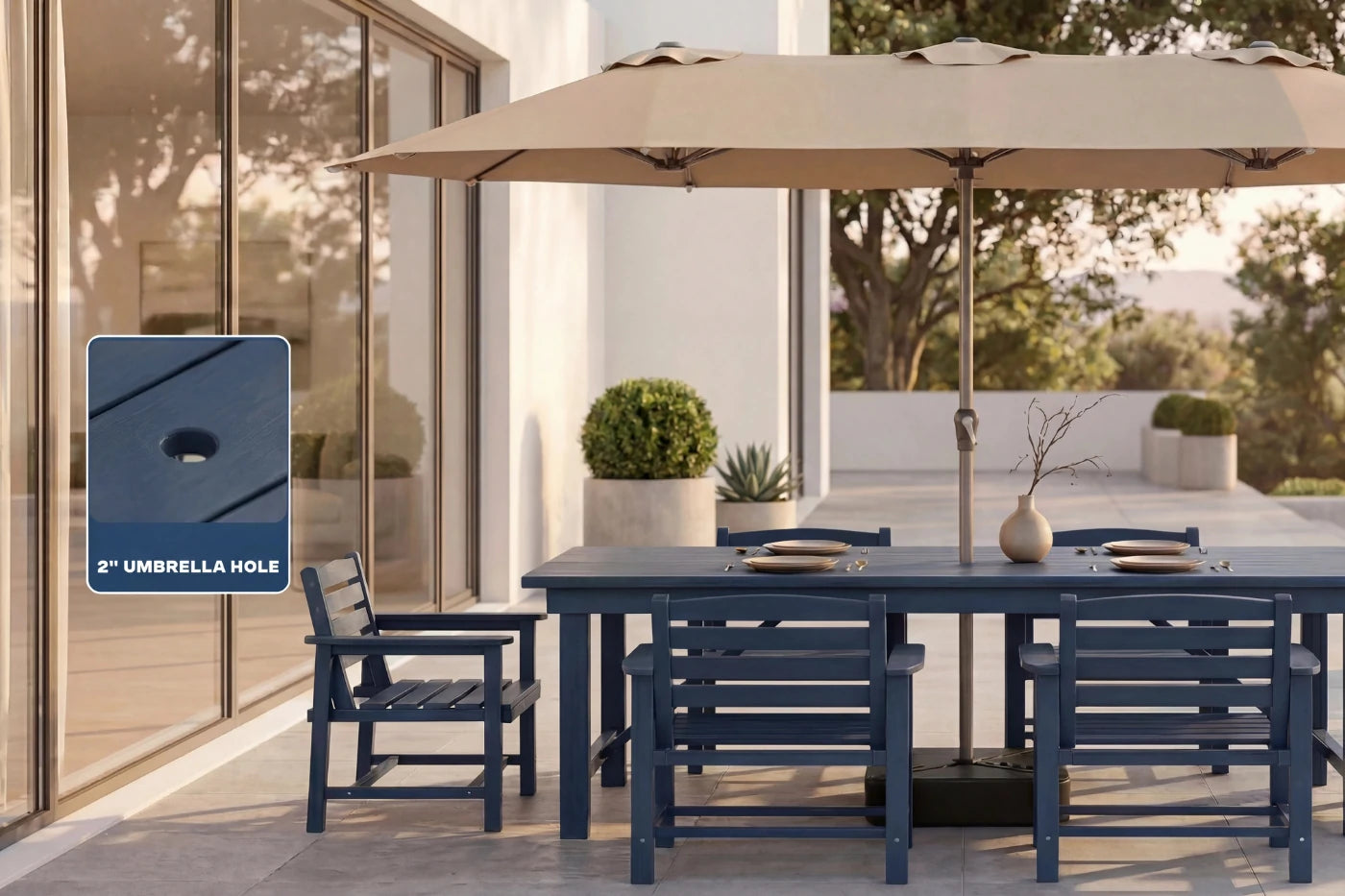 Outdoor dining set with a large beige umbrella and navy chairs on a patio.