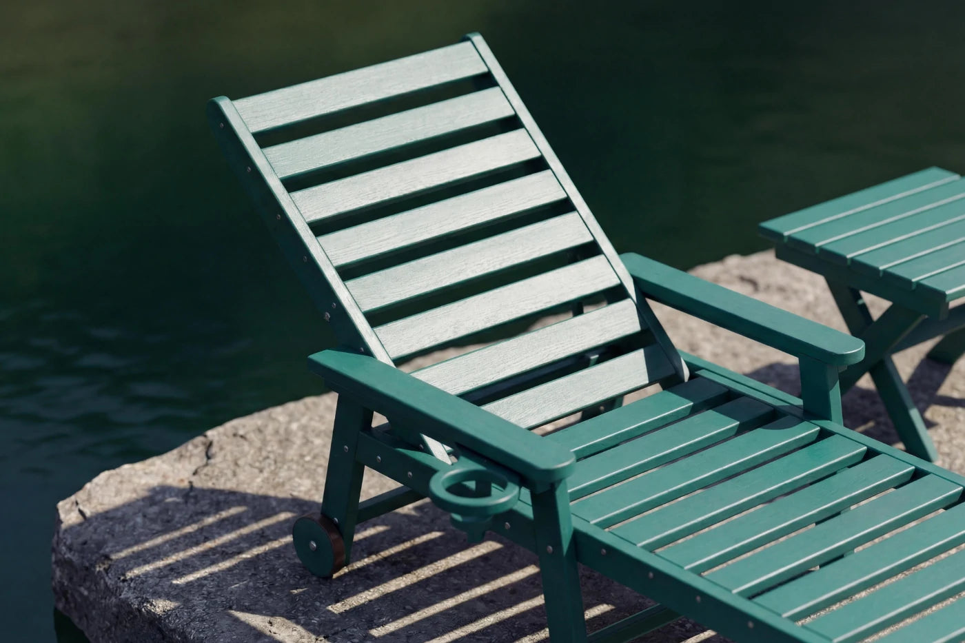 Two green lounge chairs by a body of water.