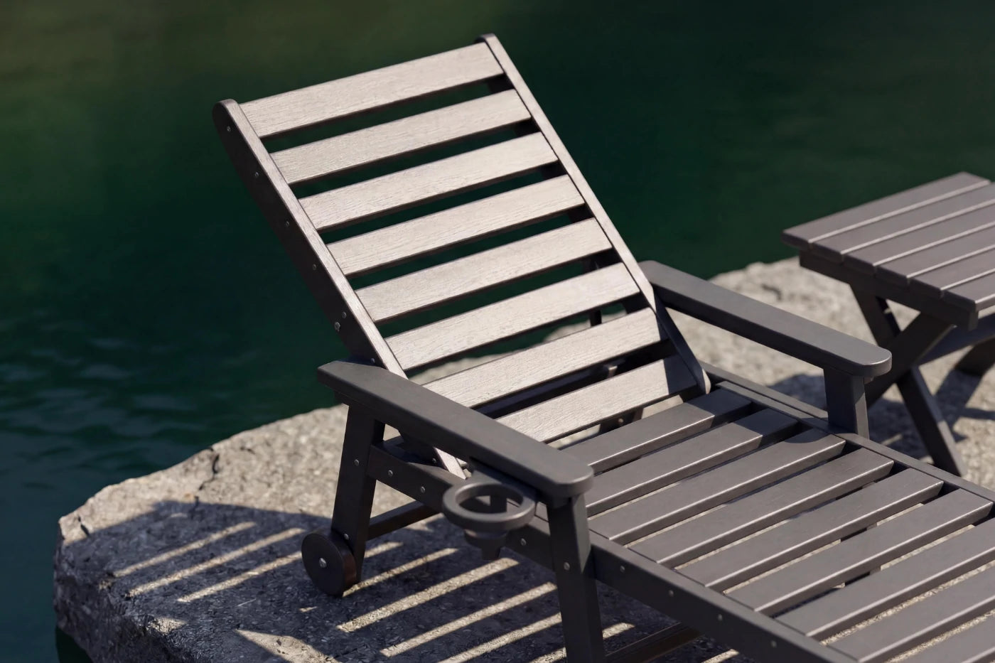 Gray lounge chair and table by a body of water