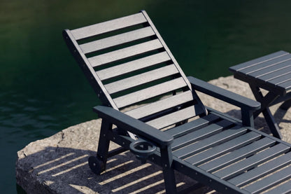 Gray lounge chair and table by a body of water