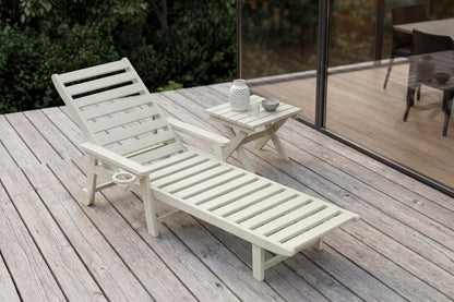 Wooden lounge chair on a wooden deck with a small table and decorative items.