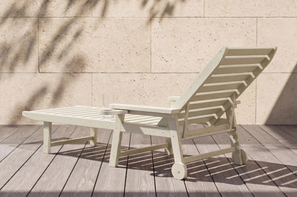 Beige lounge chair with ottoman on a wooden deck against a beige wall