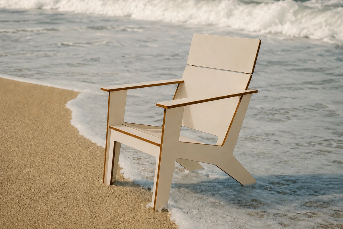 A modern poly Adirondack chair with a beige finish and medium brown edges, positioned on a sandy beach right at the edge of the ocean with waves crashing behind it.