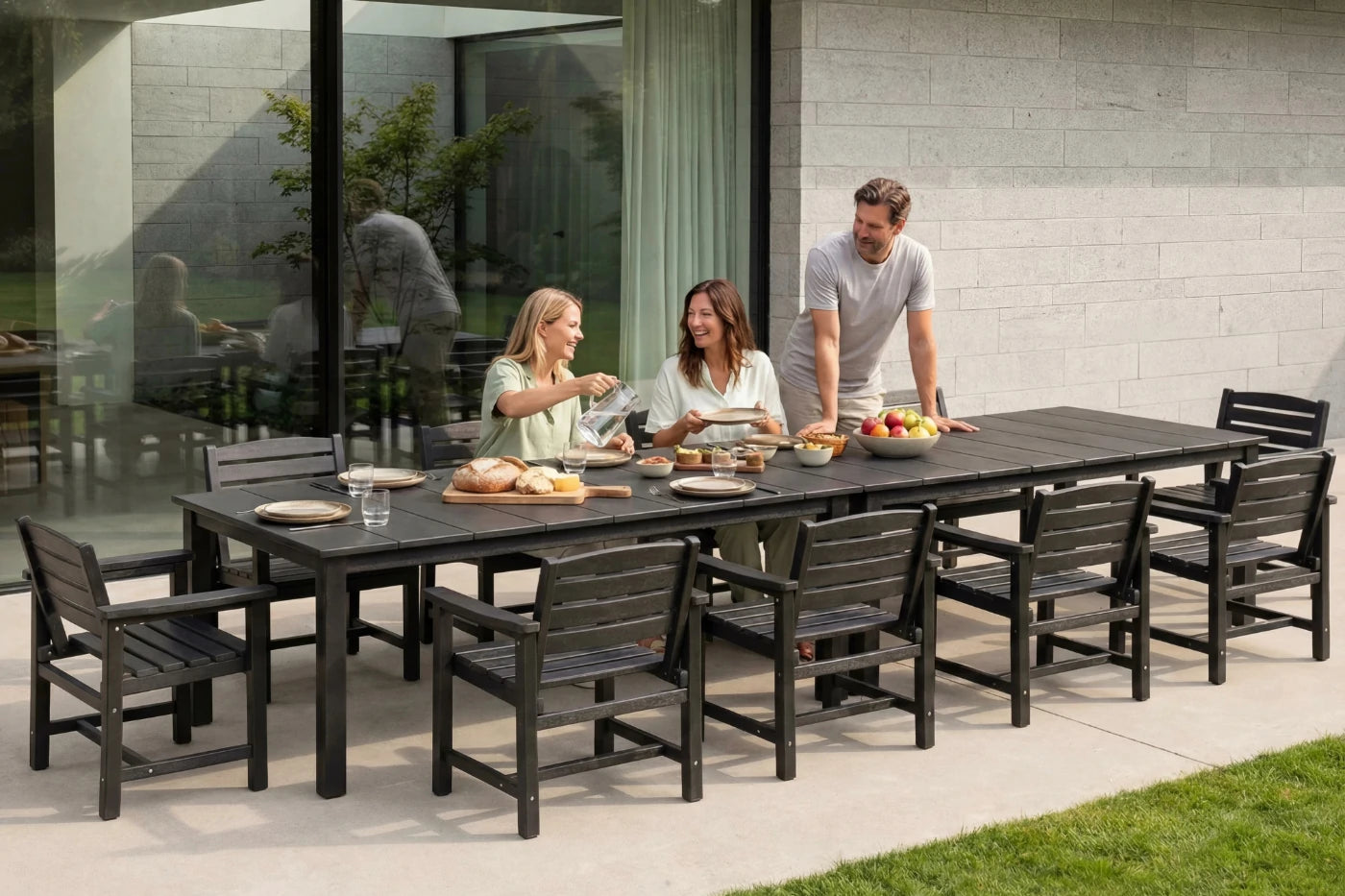 Family of four enjoying a meal outdoors at a long black dining table with chairs.