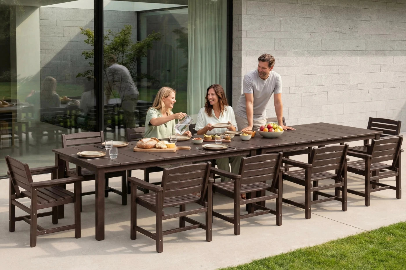 Family of four enjoying a meal outdoors at a long wooden dining table with chairs.