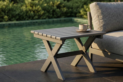 Outdoor table with a cup and saucer next to a couch by a pool