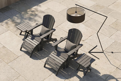Two dark gray Adirondack chairs with a matching table on a stone patio.