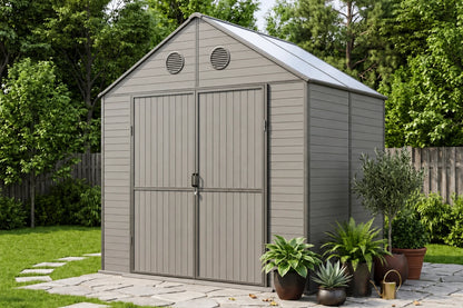 A gray resin storage shed with polycarbonate roof, shown in a landscaped backyard with potted plants, a stone path, and trees in the background.