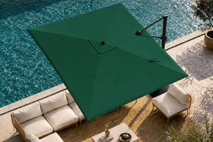 A large green patio umbrella with a cantilever arm is positioned over a modern outdoor lounge area next to a swimming pool.