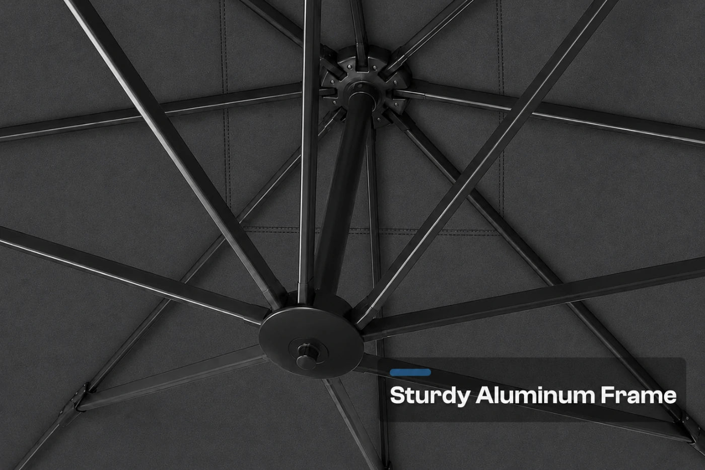 Close-up of the underside of a patio umbrella showing the dark gray canopy fabric and black aluminum frame ribs, with a text overlay that reads 'Sturdy Aluminum Frame'.