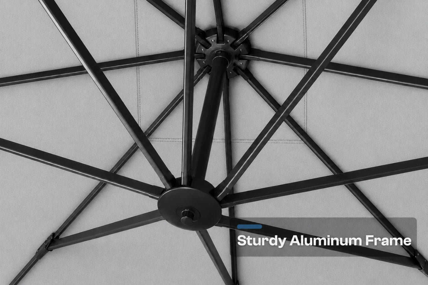 Close-up of a black aluminum patio umbrella frame with radiating ribs and a central hub, shown against a gray background with the text 'Sturdy Aluminum Frame' in the lower right.