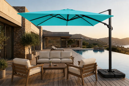 A large cantilever patio umbrella in turquoise blue with a black pole and black weighted base, shown in a luxurious outdoor setting next to a swimming pool with a wooden deck, lounge chairs, and a modern house in the background.